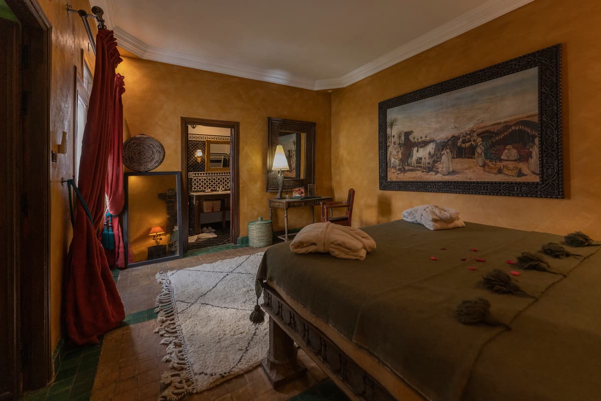 Chambre Antiqua — bois sombre, kilim et lumière tamisée
