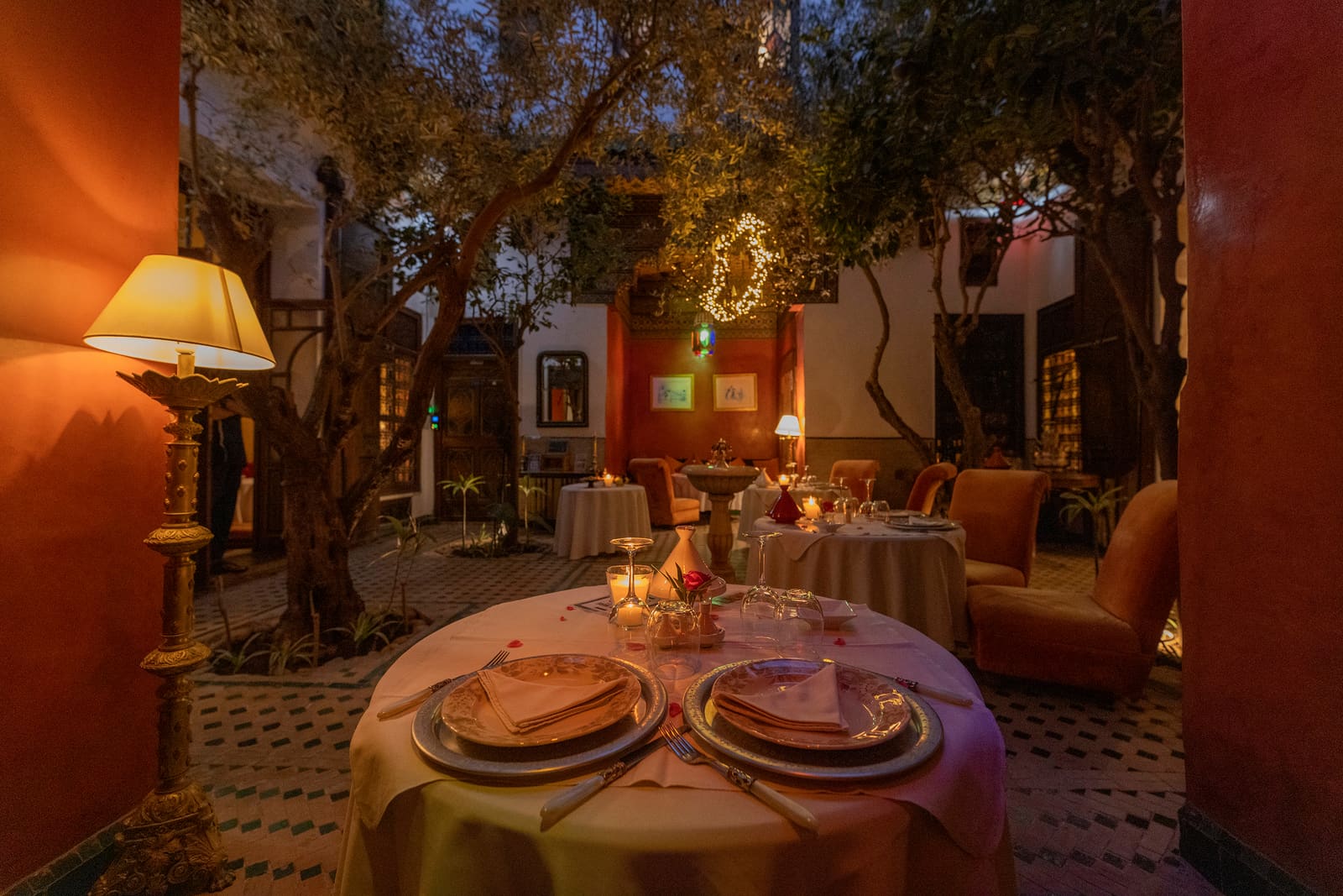 La table dressée sous l'olivier du grand patio, à l'ombre des palmiers